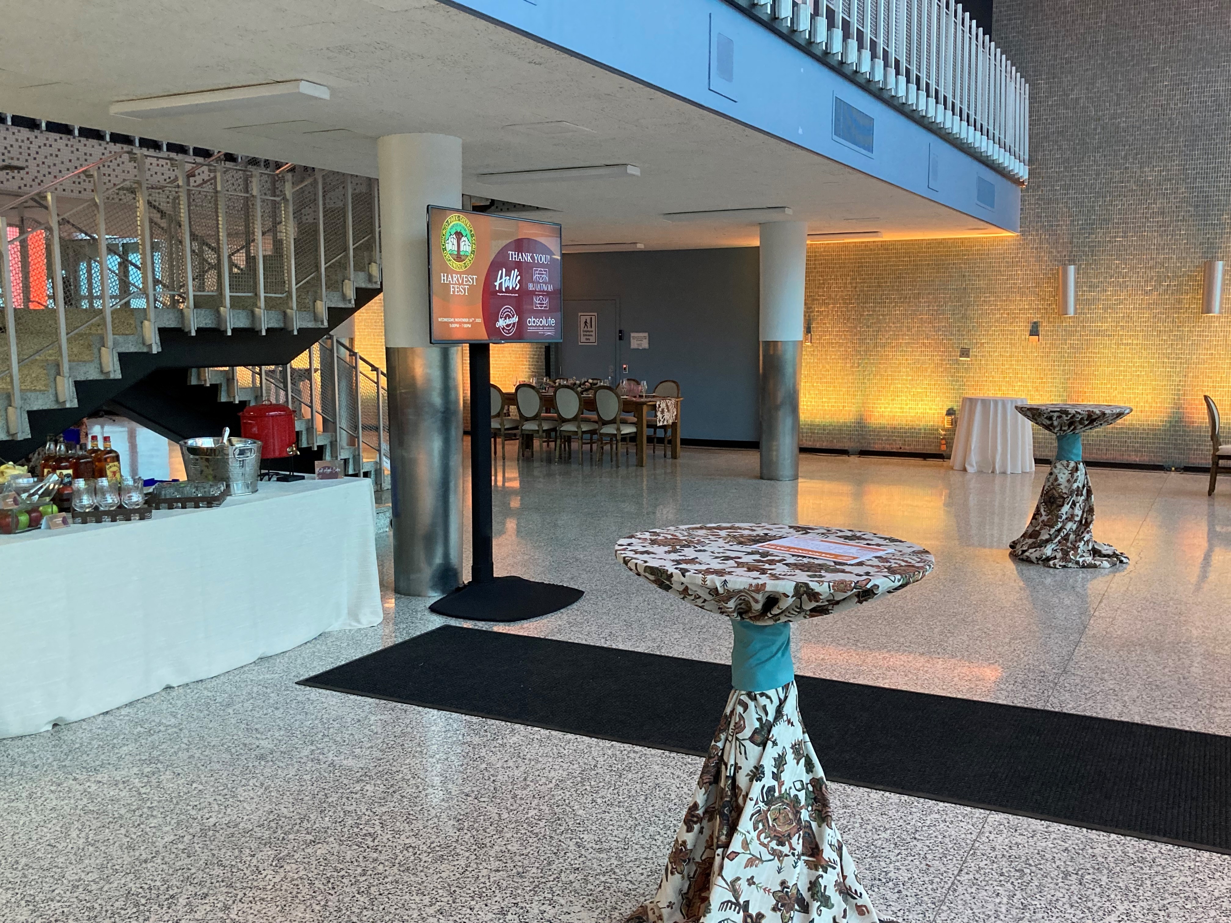 Event space set up with decorated cocktail tables and a buffet.